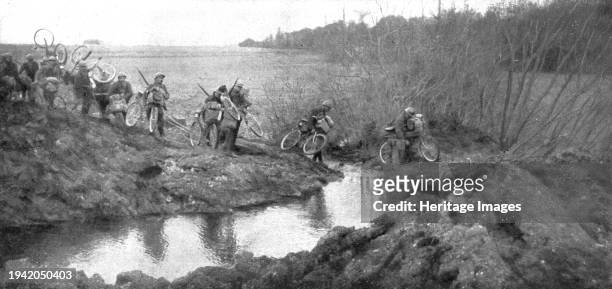 Avance Francaise; La traversee d'un ruisseau par un groupe cycliste: il existait la un petit pont que les allemands ont de truit ; nos hommes ont...
