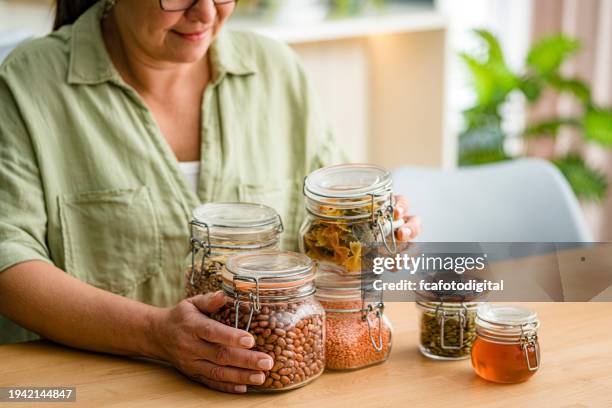 woman using glass jars to storage dried food - lentil stock pictures, royalty-free photos & images