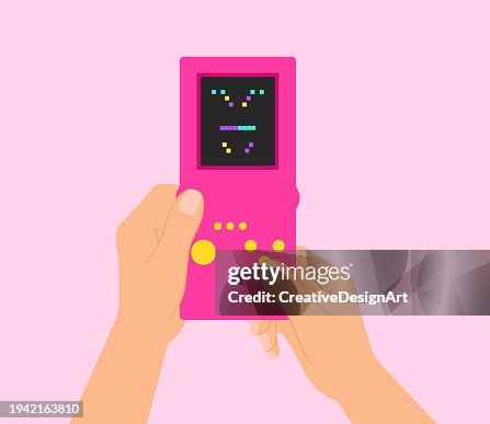 Hand Holding Retro Game Console And Playing Block Stacking Video Game Hand Holding Retro Game Console And Playing Block Stacking Video Game