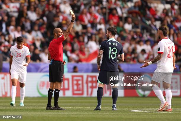 Referee Adel Ali Alnaqbi shows a yellow card to Aiden O'Neill of Australia during the AFC Asian Cup Group B match between Syria and Australia at...