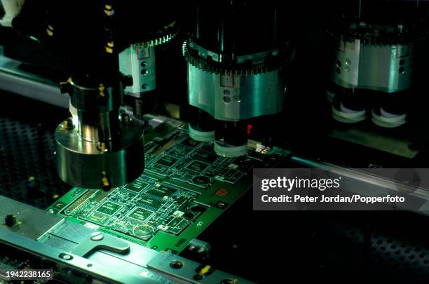 Machine checks integrated circuit microchips mounted on a circuit board on a sealed production line at the Panasonic company's phone production...