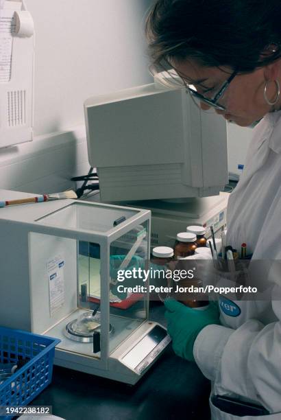 Researcher uses a weighing machine to measure a drug sample in a laboratory at a research facility of the Pfizer drug company at their Discovery Park...