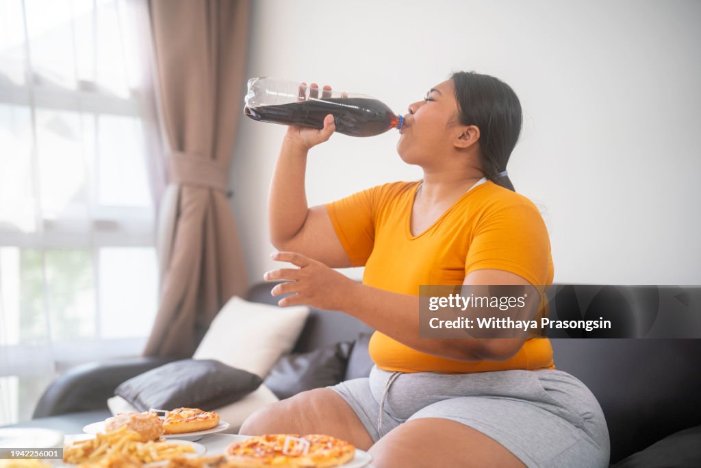 Asian fat girl hungry and eat a junk food on the table
