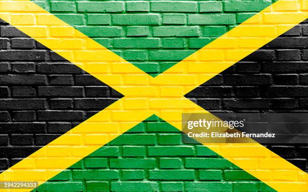 jamaica flag on brick wall - jamaica stock pictures, royalty-free photos & images