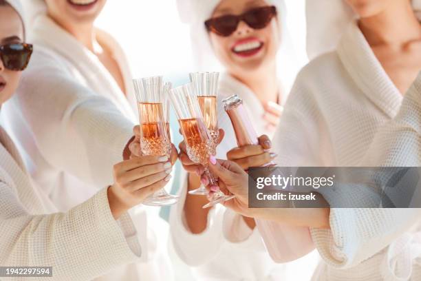 freundinnen in weißen bademänteln vor einem junggesellinnenabschied stoßen mit champagner an - junggesellinnenabschied stock-fotos und bilder