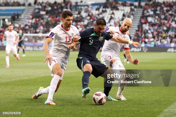 Bruno Fornaroli of Australia is challenged by Thaer Krouma and Abdul Rahman Weiss of Syria during the AFC Asian Cup Group B match between Syria and...