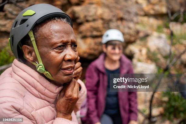 mujer mayor activa que se prepara para la aventura de escalada de montaña - casco de trabajo fotografías e imágenes de stock