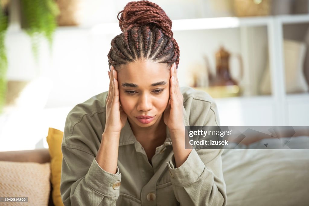 Worried young women sitting on sofa at home