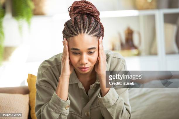 worried young women sitting on sofa at home - tearing your hair out stock pictures, royalty-free photos & images