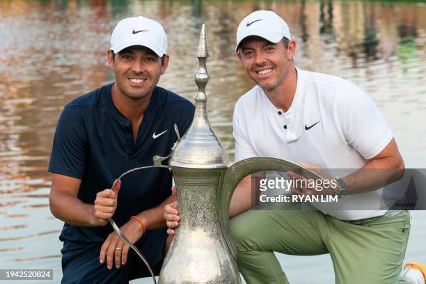 Rory McIlroy of Northern Ireland poses with his caddy Harry Diamond next to his trophy after winning the Hero Dubai Desert Classic on the Majlis...