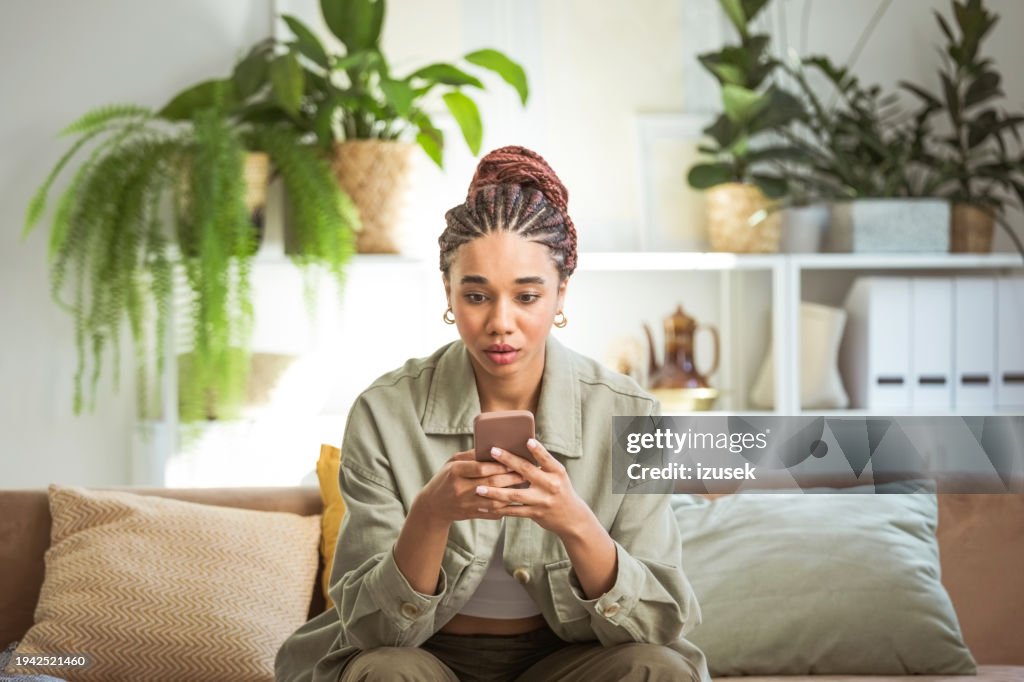 Worried young women using smart phone at home