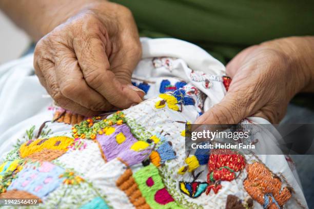 woman does handmade embroidery with thread and needle - máquina de costura imagens e fotografias de stock