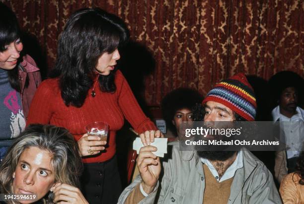 American actor Elliott Gould talks to a fan after signing a napkin at an event, US, circa 1971.