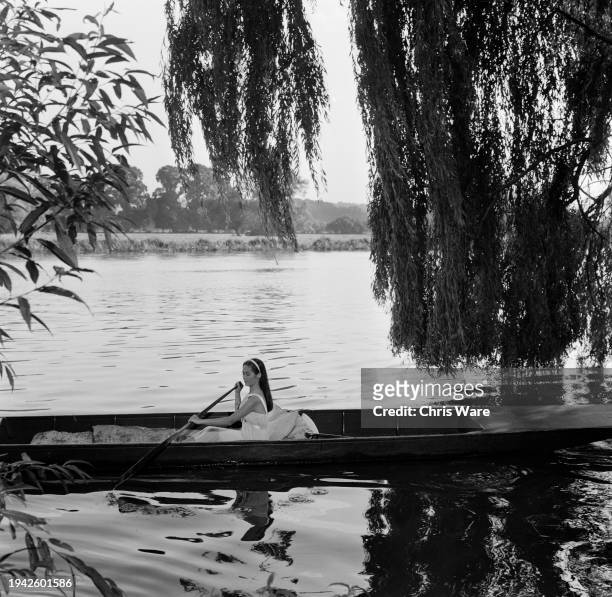 Chinese-American actress Nancy Kwan rowing a boat in a scene from 'Tamahine' on the River Thames at Henley, Oxfordshire, September 1962.