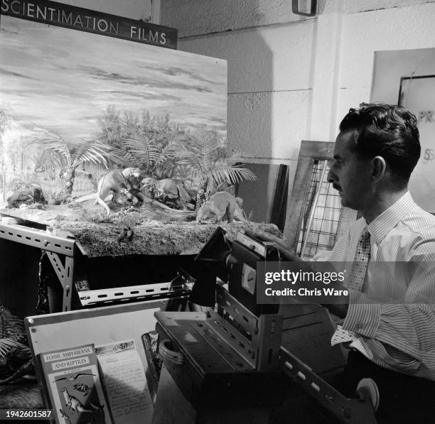 Artist Arthur Hayward working on a stop motion film featuring dinosaur models at his workshop in Perivale, London, September 1962. Hayward designed...