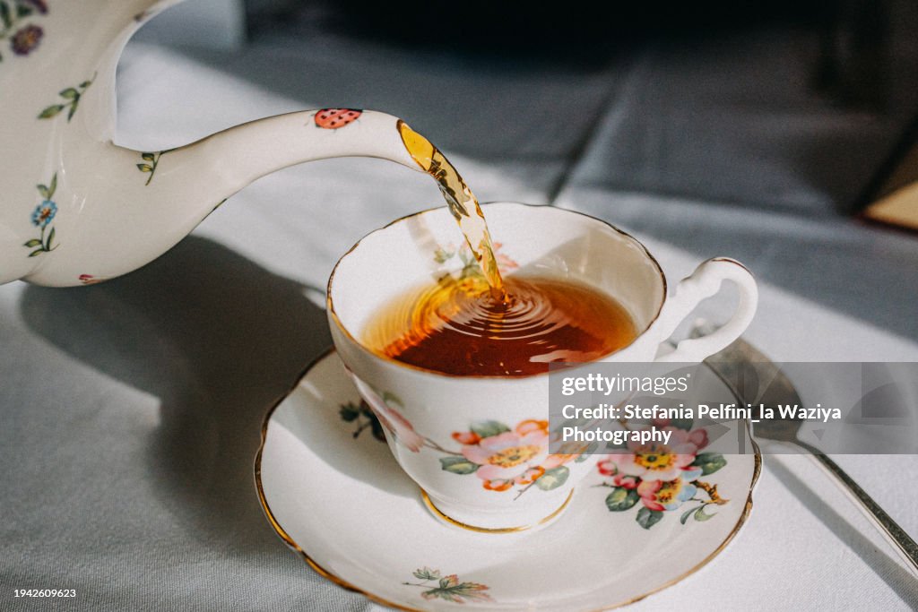 Vintage Teapot Pouring Tea in Tea cup