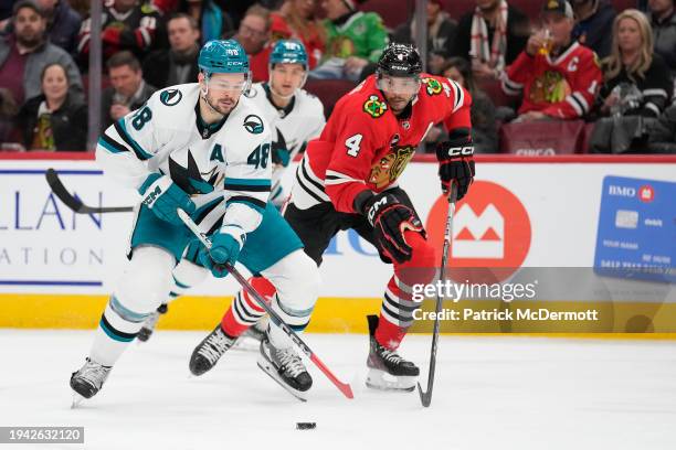 Tomas Hertl of the San Jose Sharks skates with the puck against Seth Jones of the Chicago Blackhawks during the third period at the United Center on...