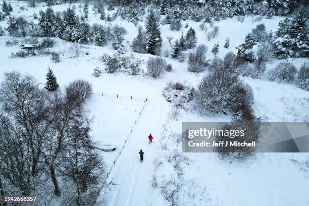 Members of the public walk in the snow as the met office issued weather alerts as low temperatures continued across the north of the country on...