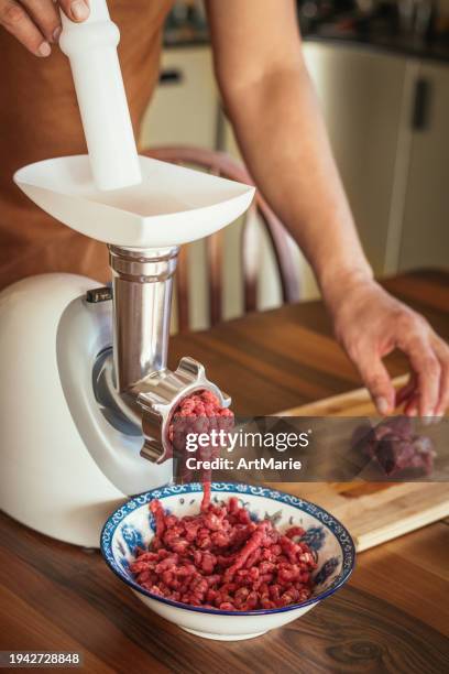 man making mince with electric meat grinder at a domestic kitchen - meat grinder stock pictures, royalty-free photos & images