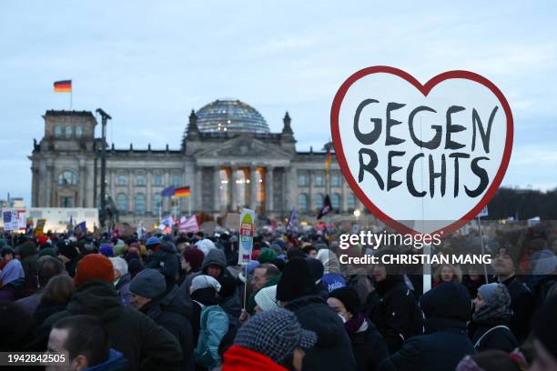 Participant holds up a heart-shaped placard reading 'Against the right wing' during a demonstration against racism and far right politics in front of...