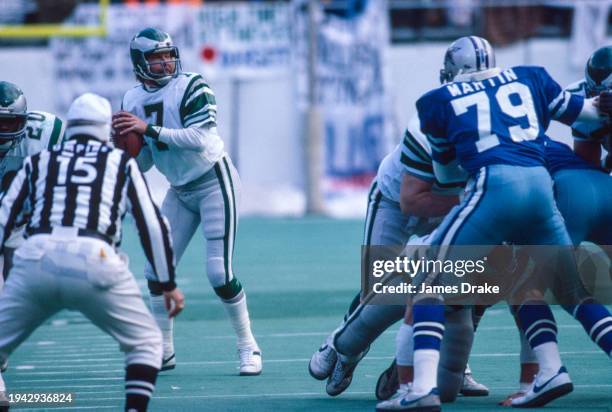 Philadelphia Eagles quarterback Ron Jaworski drops back to pass as Dallas Cowboys defensive end Harvey Martin muscles in during the NFC Championship...