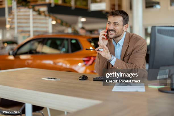 car dealer talking on mobile phone - car dealership phone stock pictures, royalty-free photos & images