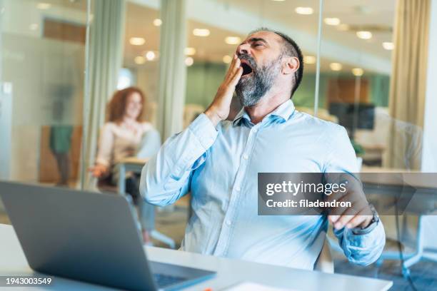 bored or tired business man yawning in office - yawning stock pictures, royalty-free photos & images