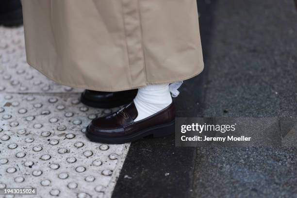 Fashion Week Guest is seen wearing a beige long coat, white socks with loops, Dior black loafer during the Amiri Menswear Fall/Winter 2024/2025 as...