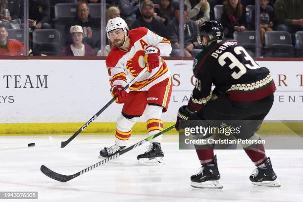 Rasmus Andersson of the Calgary Flames shoots the puck past Travis Dermott of the Arizona Coyotes during the first period of the NHL game at Mullett...