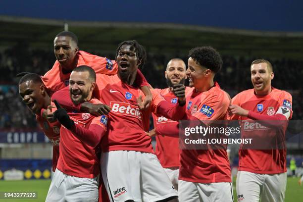 Rouen's French midfielder Omar Bzzekhami celebrates with his teammates after scoring his team first goal during the French Cup round of 32 football...