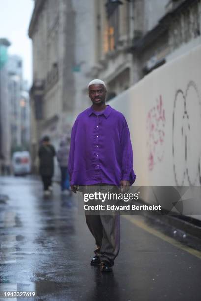 Dan Clement wears a purple oversized shirt, flared suit pants, black leather shoes, outside Bluemarble, during the Menswear Fall/Winter 2024/2025 as...
