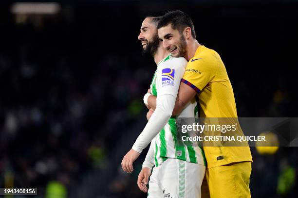 Barcelona's Spanish forward Ferran Torres hugs Real Betis' Spanish midfielder Isco during the Spanish League football match between Real Betis and FC...