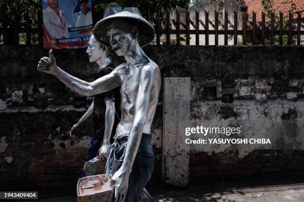 Street performers poses as they walk on a street in Jakarta on January 21, 2024.