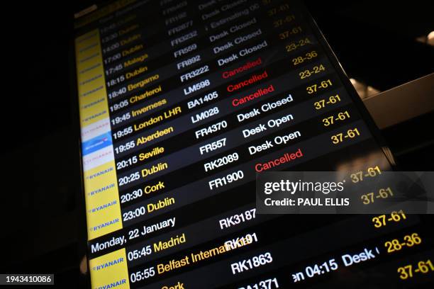 The arrivals board at Manchester Airport shows many flights cancelled or delayed due to high winds caused by Storm Isha on January 21, 2024. Amber...