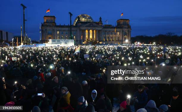 Participants light with their mobile phones during a demonstration against racism and far right politics in front of the Reichstag building in...