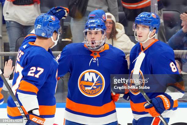 Alexander Romanov of the New York Islanders is congratulated by Anders Lee and Noah Dobson after scoring a goal against the Dallas Stars during the...