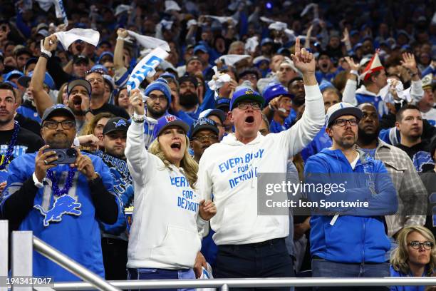 Detroit fans wearing sweatshirts with the saying "Everybody for Detroit" cheer during an NFL NFC Divisional playoff football game between the Tampa...