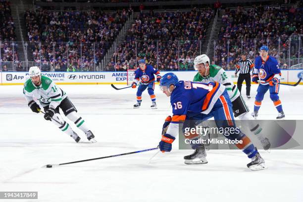 Julien Gauthier of the New York Islanders is defended by Joe Pavelski of the Dallas Stars during the first period at UBS Arena on January 21, 2024 in...
