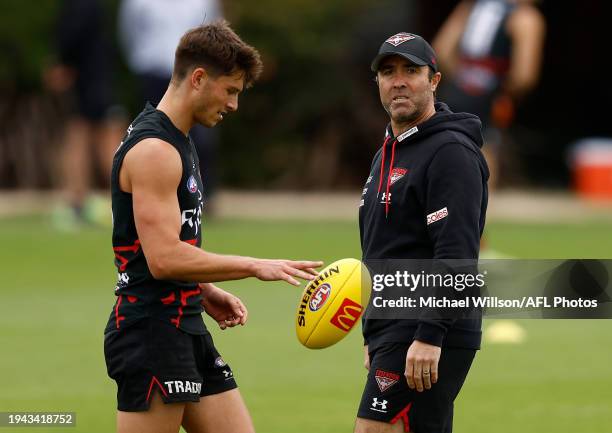 Archie Perkins of the Bombers and Brad Scott, Senior Coach of the Bombers chat during the Essendon Bombers training session at the NEC Hangar on...