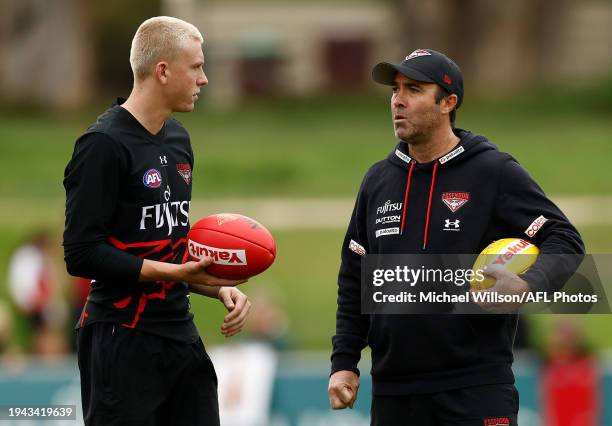 Nate Caddy and Brad Scott, Senior Coach of the Bombers chat during the Essendon Bombers training session at the NEC Hangar on January 22, 2024 in...