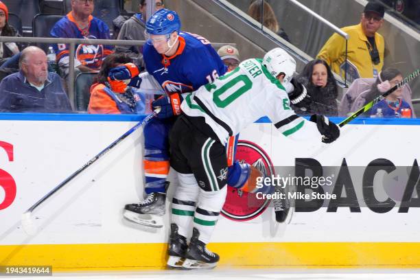 Julien Gauthier of the New York Islanders is checked into the boards by Ryan Suter of the Dallas Stars during the third period at UBS Arena on...