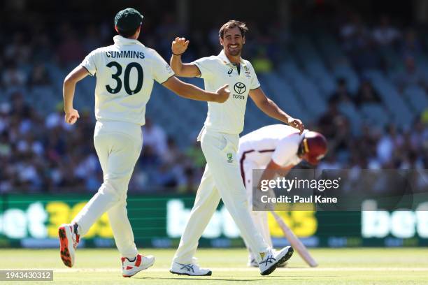 Pat Cummins of Australia congratulates Mitchell Starc of Australia as he celebrates taking the wicket of Joshua Da Silva of the West Indies during...