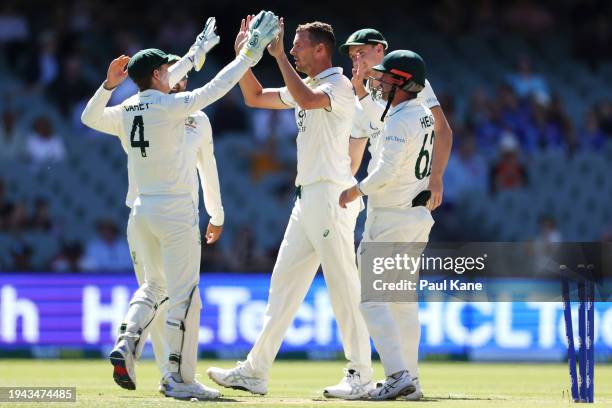 Josh Hazlewood of Australia celebrates with his team mates after taking the wicket of Gudakesh Motie of the West Indies during day three of the Mens...