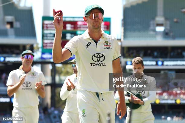 Josh Hazlewood of Australia holds up the match ball as he acknowledges the crowd after taking 5 wickets in the West Indies second innings during day...