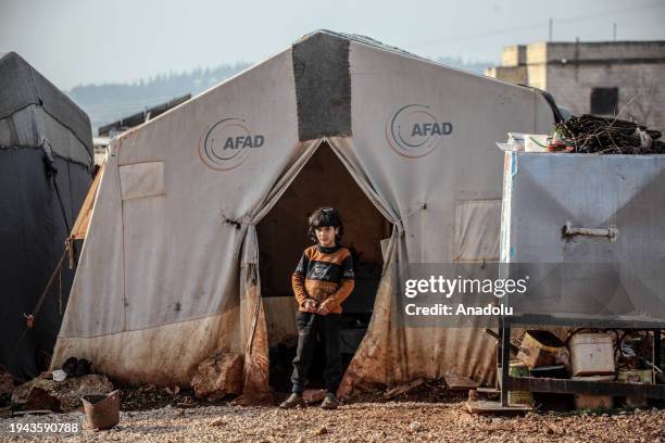 Syrian child, who has to struggle with hard life conditions and cold winter as a refugee in Bettin Camp, is seen in front of a tent in Idlib, Syria...