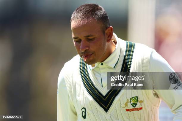 Usman Khawaja of Australia leaves the field retiring hurt after he was struck while batting during day three of the Mens Test match series between...