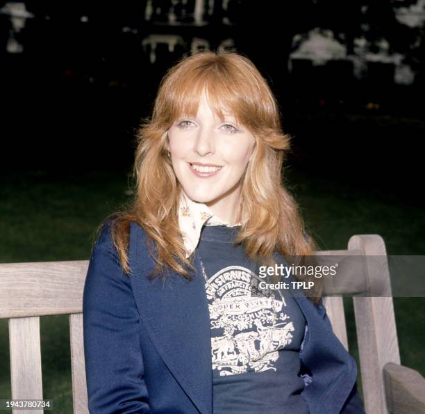English actress Patricia Hodge poses for a portrait sitting on a bench, wearing a Levi Strauss and company shirt in London, England, October 10, 1973.