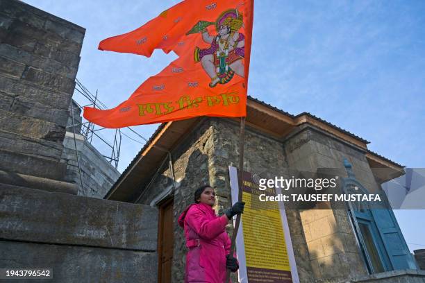 Hindu devotee waves a religious flag at the Shankaracharya temple in Srinagar on January 22 on the occasion of Ayodhya Ram temple's consecration...
