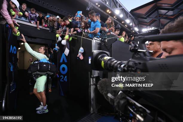 Germany's Alexander Zverev signs autographs to his fans after his victory against Britain's Cameron Norrie during their men's singles match on day...