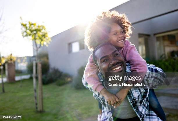 loving father playing with her daughter outside their house - milestone stockfoto's en -beelden